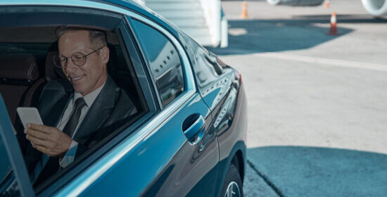Man-in-chauffeur-car-next-to-airplane-550x550